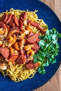 Garlic noodles topped with seasoned crawfish and a fried egg