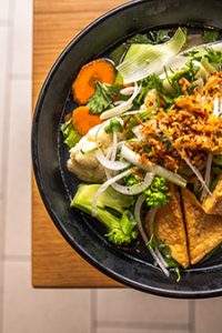 Vegetarian pho with tofu, greens, carrots, and fresh onion